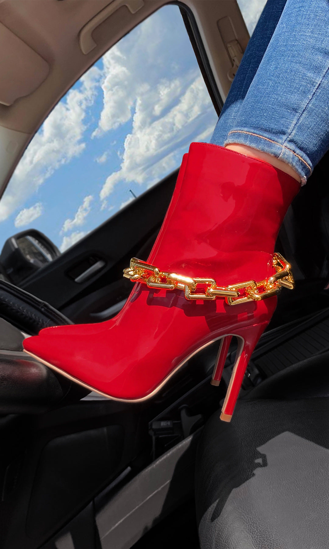 DESIGNER CHICA EN CARRO CON BOTAS ALTAS DE COLOR ROJO Y CADENAS DORADAS EN TENDENCIA 